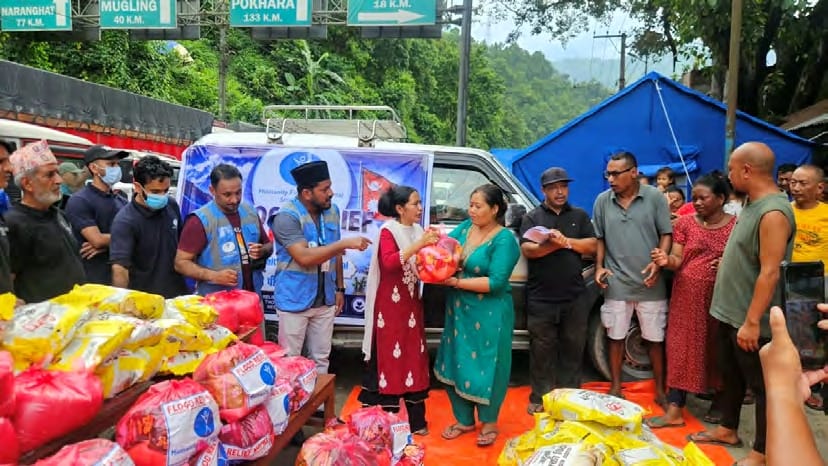 A woman receives a food kit at a roadside distribution in Dhading