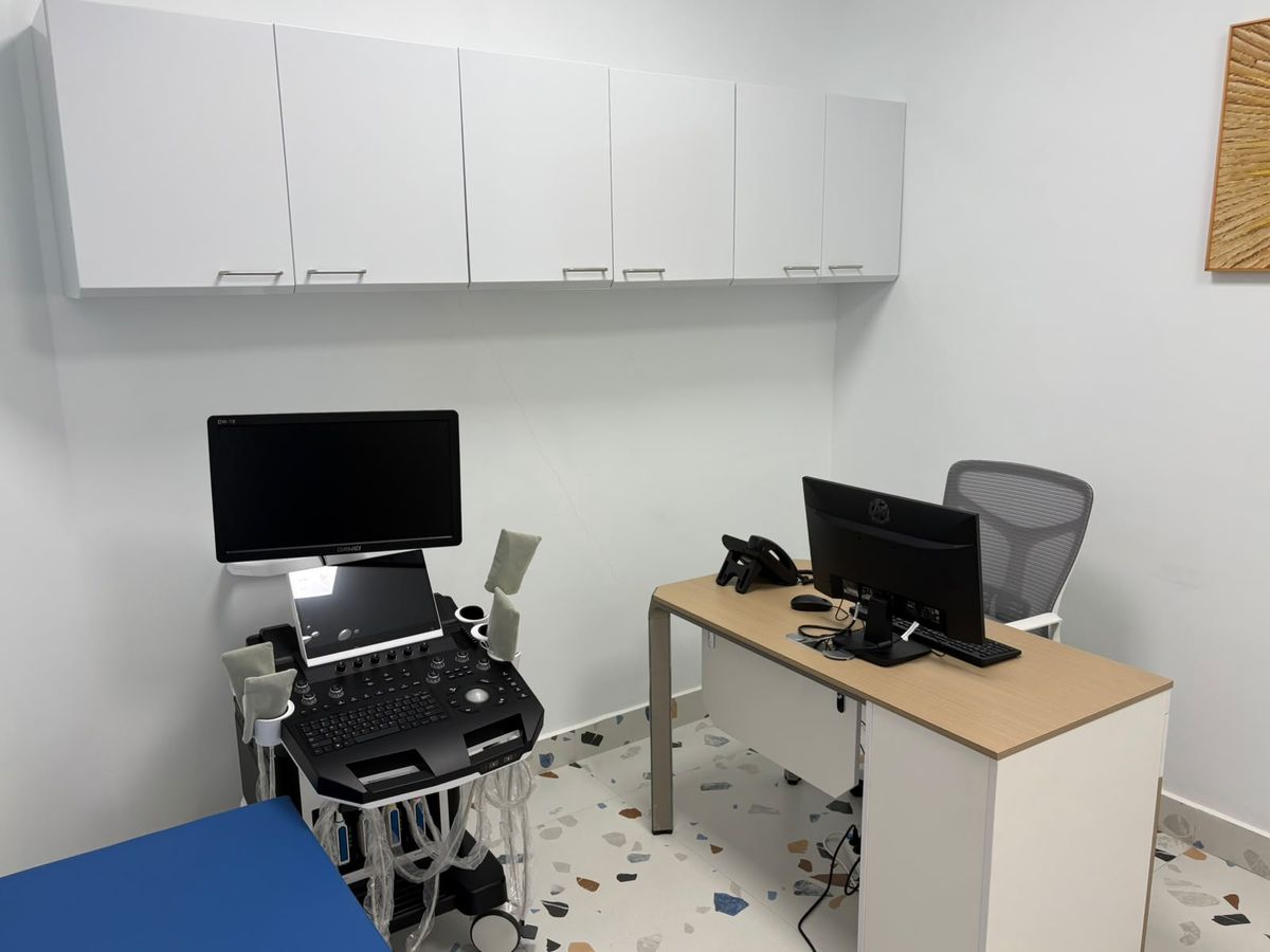 A consultation room with an ultrasound machine and a clinician's desk