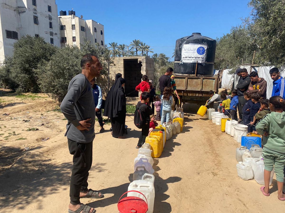 Families collecting clean water from a mobile water tank in Gaza