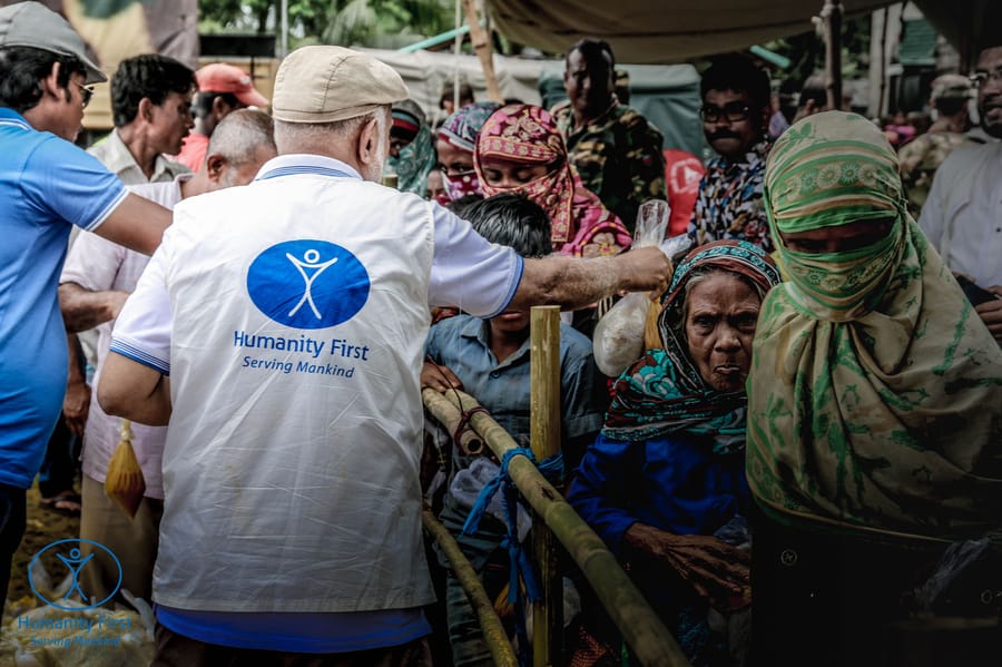 A Humanity First UK volunteer hands a food parcel to a Rohingya family in Bangladesh, 2017