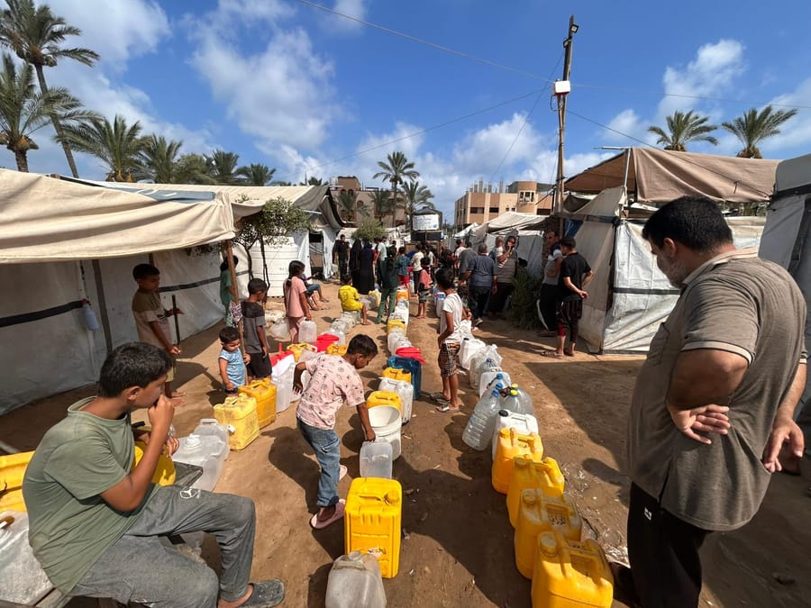 Clean water distribution at a tented camp in Gaza