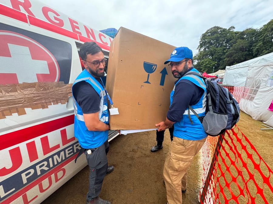 A Humanity First worker lifting a box of aid supplies in La Guaira